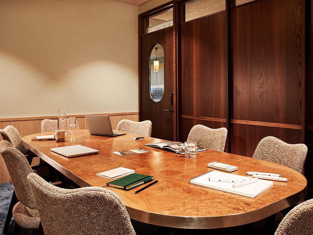 Private meeting room with a long wooden table, chairs and a wooden door