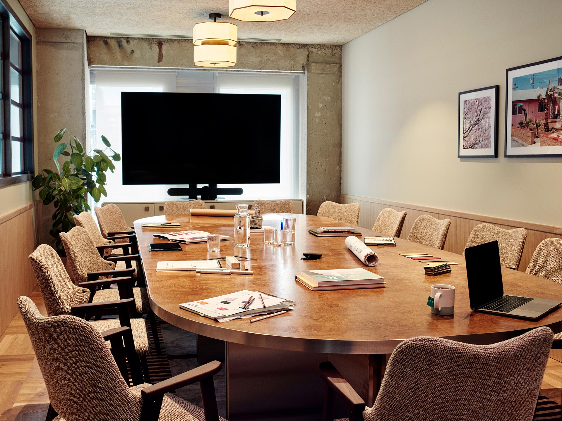 The Big One meeting room with a large oval table, fourteen chairs and a presentation screen